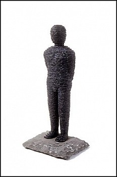 Boaz Vaadia Zevulun (#25) (1995), bronze and bluestone sculpture, 21 x 10 x 8 inches. A layered stone human figure standing on a natural stone base, symbolizing Vaadia&acirc;s connection to nature, timeless human form, and the organic process of sculptural crea