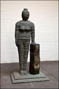 Boaz Vaadia Hulda (#111) (2011), bronze, basalt, and bluestone sculpture, 79 1/2 x 41 x 29 inches. The figure stands tall beside a basalt block, showcasing Vaadia&acirc;s signature layered stone aesthetic, inspired by nature and archaeology.