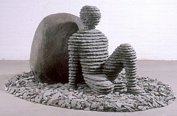 Boaz Vaadia Ginnetoy 2nd (#78) (2004), a bronze, bluestone, and boulder sculpture, featuring a reclining layered stone figure leaning against a boulder. A contemporary sculptural piece reflecting human connection to nature. Available at Sponder Gallery.